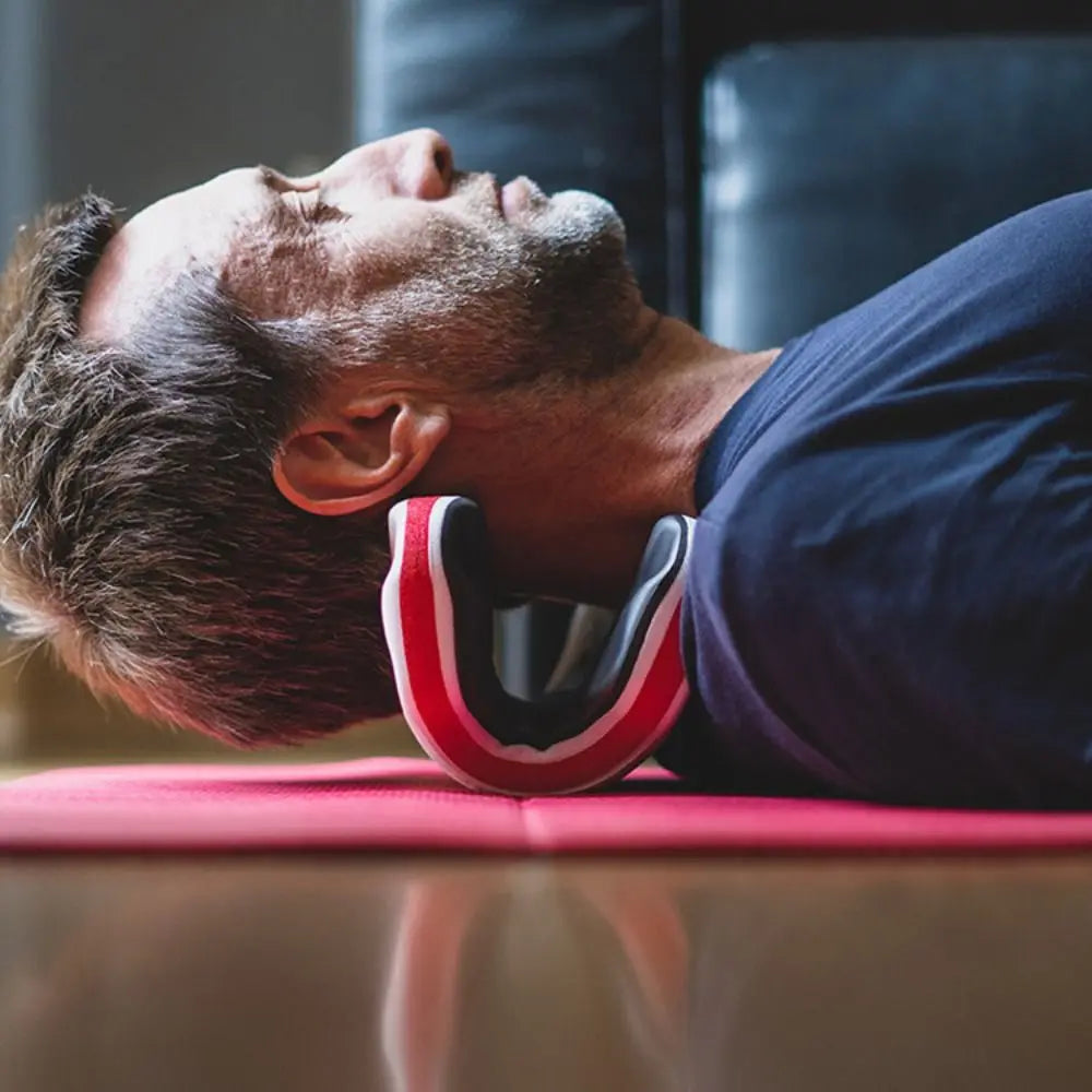 Person lying down using a cervical traction pillow to relieve tech neck